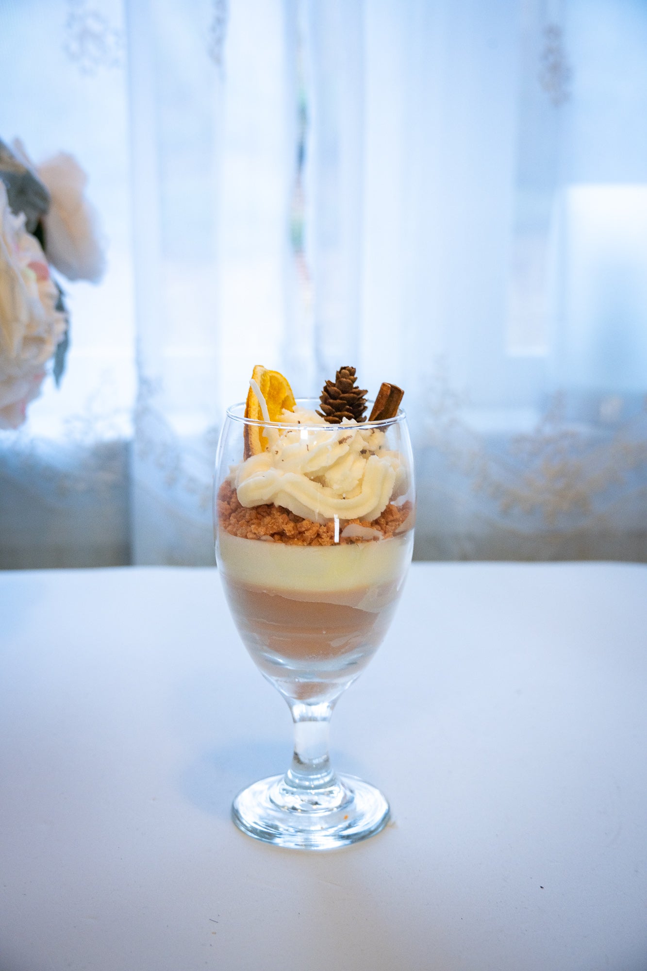 This beautifully crafted Macchiato&nbsp;parfait dessert is featured by&nbsp;foamed milk on espresso, layering on top with crumbled biscuit and whipped cream, garnished with a dried orange slice, a small pine cone, and a cinnamon stick, suggesting autumnal or winter seasonal flavors. Enjoy this lovely&nbsp;treat!
