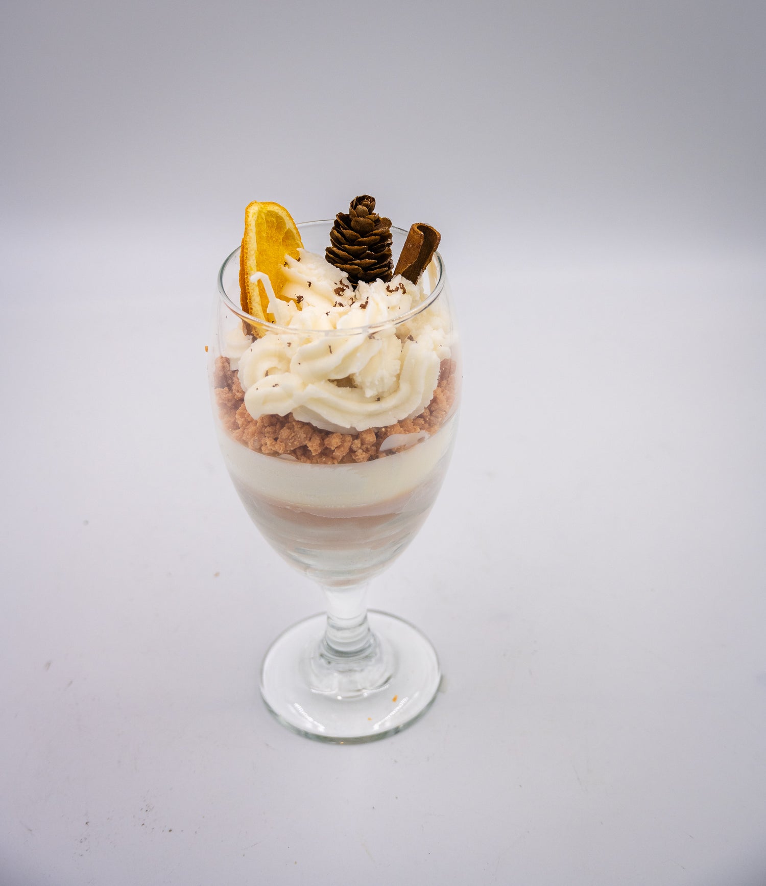 This beautifully crafted Macchiato&nbsp;parfait dessert is featured by&nbsp;foamed milk on espresso, layering on top with crumbled biscuit and whipped cream, garnished with a dried orange slice, a small pine cone, and a cinnamon stick, suggesting autumnal or winter seasonal flavors. Enjoy this lovely&nbsp;treat!
