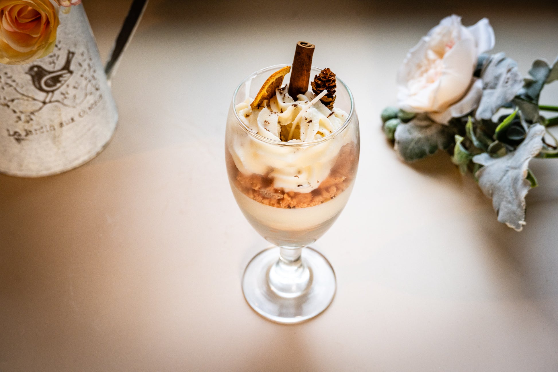 This beautifully crafted Macchiato&nbsp;parfait dessert is featured by&nbsp;foamed milk on espresso, layering on top with crumbled biscuit and whipped cream, garnished with a dried orange slice, a small pine cone, and a cinnamon stick, suggesting autumnal or winter seasonal flavors. Enjoy this lovely&nbsp;treat!
