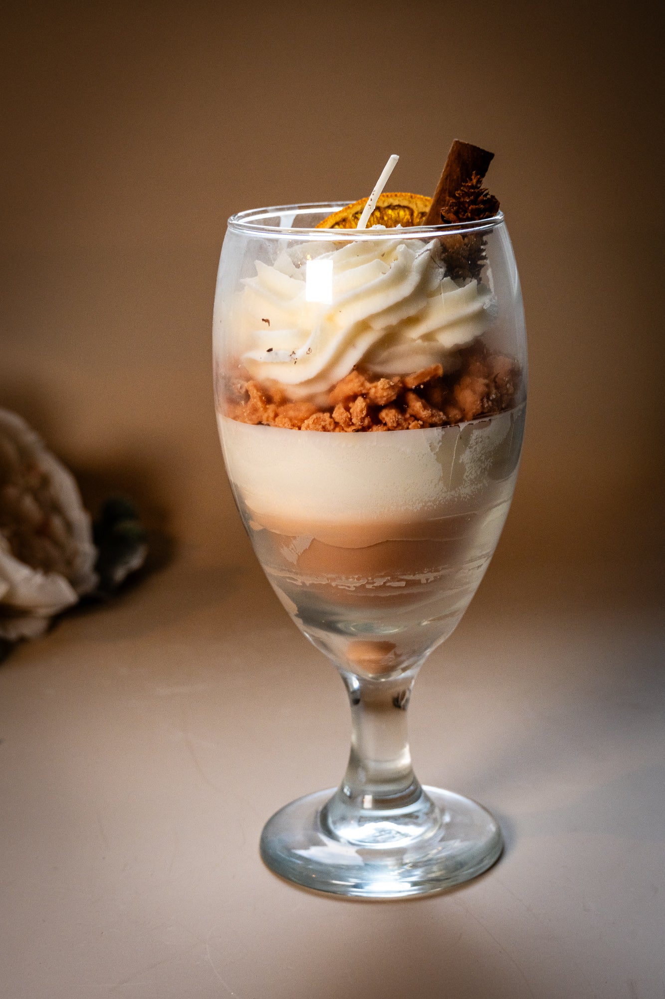 This beautifully crafted Macchiato&nbsp;parfait dessert is featured by&nbsp;foamed milk on espresso, layering on top with crumbled biscuit and whipped cream, garnished with a dried orange slice, a small pine cone, and a cinnamon stick, suggesting autumnal or winter seasonal flavors. Enjoy this lovely&nbsp;treat!
