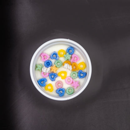This handcrafted cereal candle is a whimsical home decor piece that perfectly mimics a bowl of colorful fruit loops cereal floating in white milk, providing a delightful, nostalgic aroma of the classic breakfast treat. It's a fun, foodie item designed to evoke happy childhood memories. 